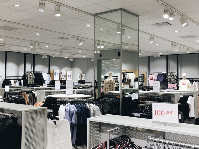 Inside view of a clothing store with women's clothes racks and displays