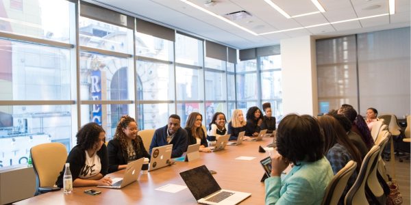 Large group of coworkers around large table in discussion